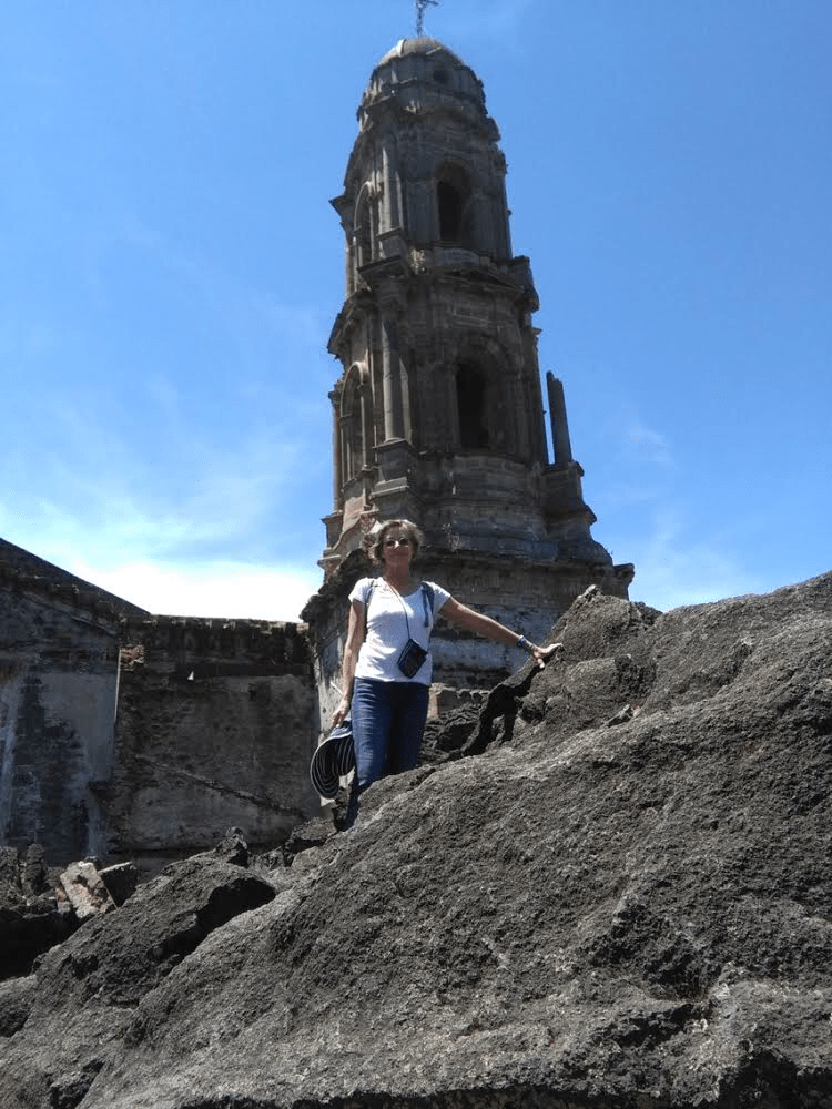 Visiting Patzcuaro in Mexico, standing in front of some architecture with a blue sky