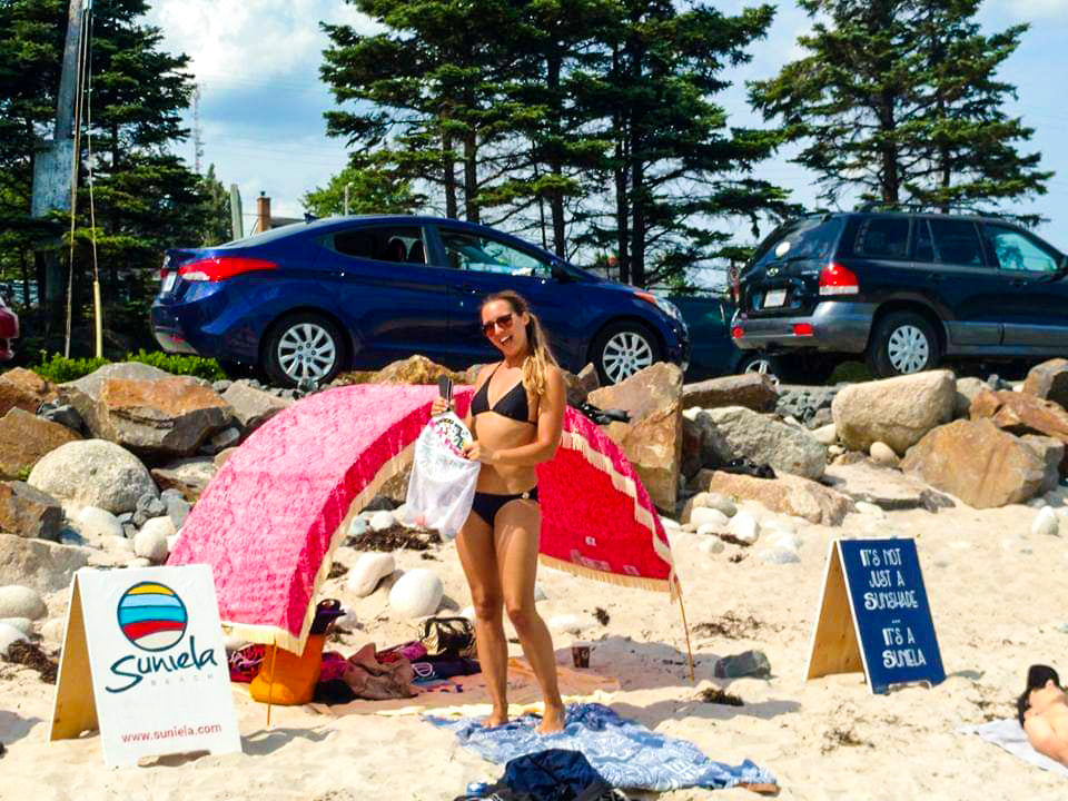 Suniela Beach founder Daniela Rojo stands in front of her patented shade cabana and signage at Queensland Beach, NS, Canada in 2015