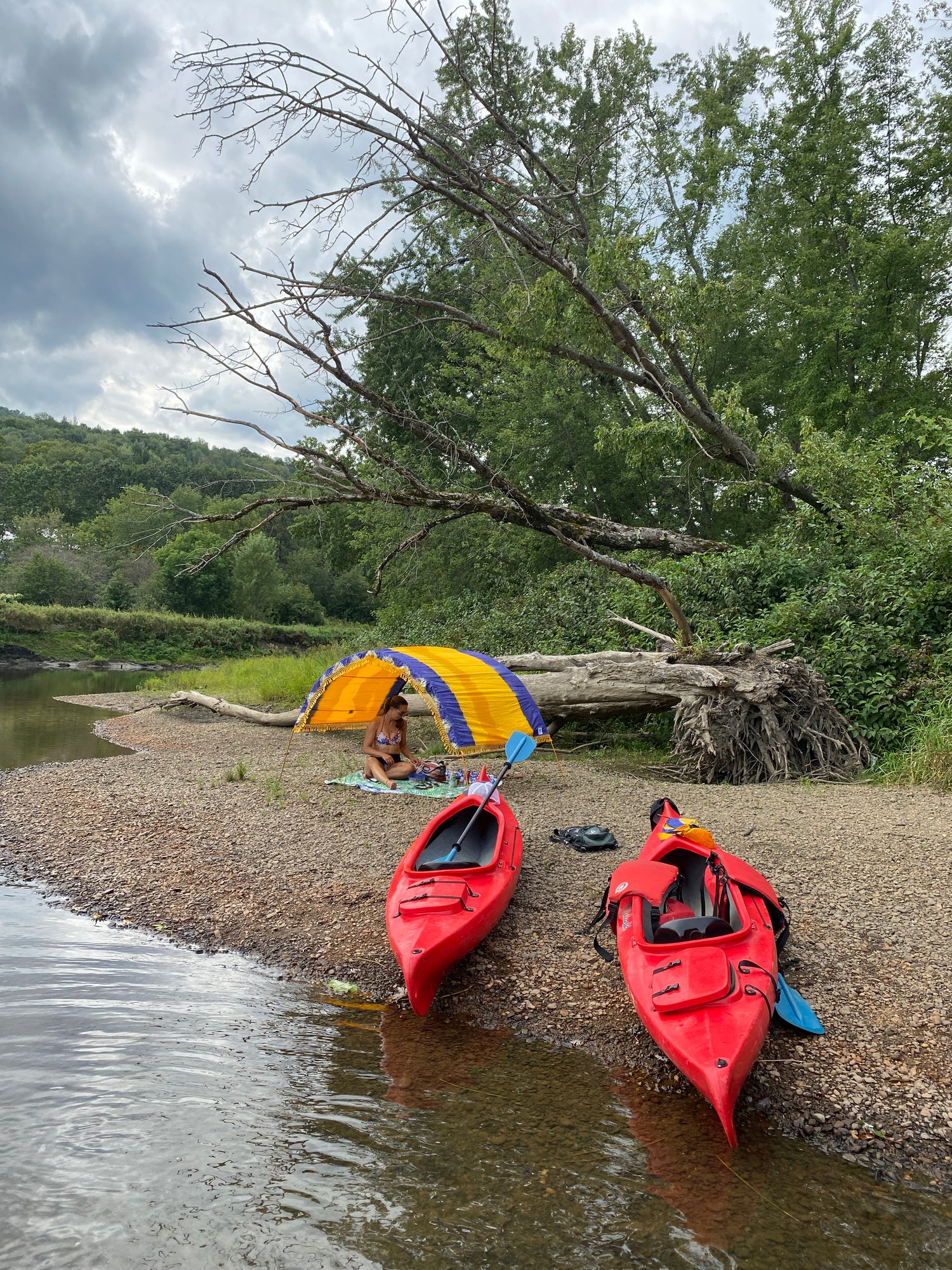 Portable beach cabana on pebble beach with kayaks