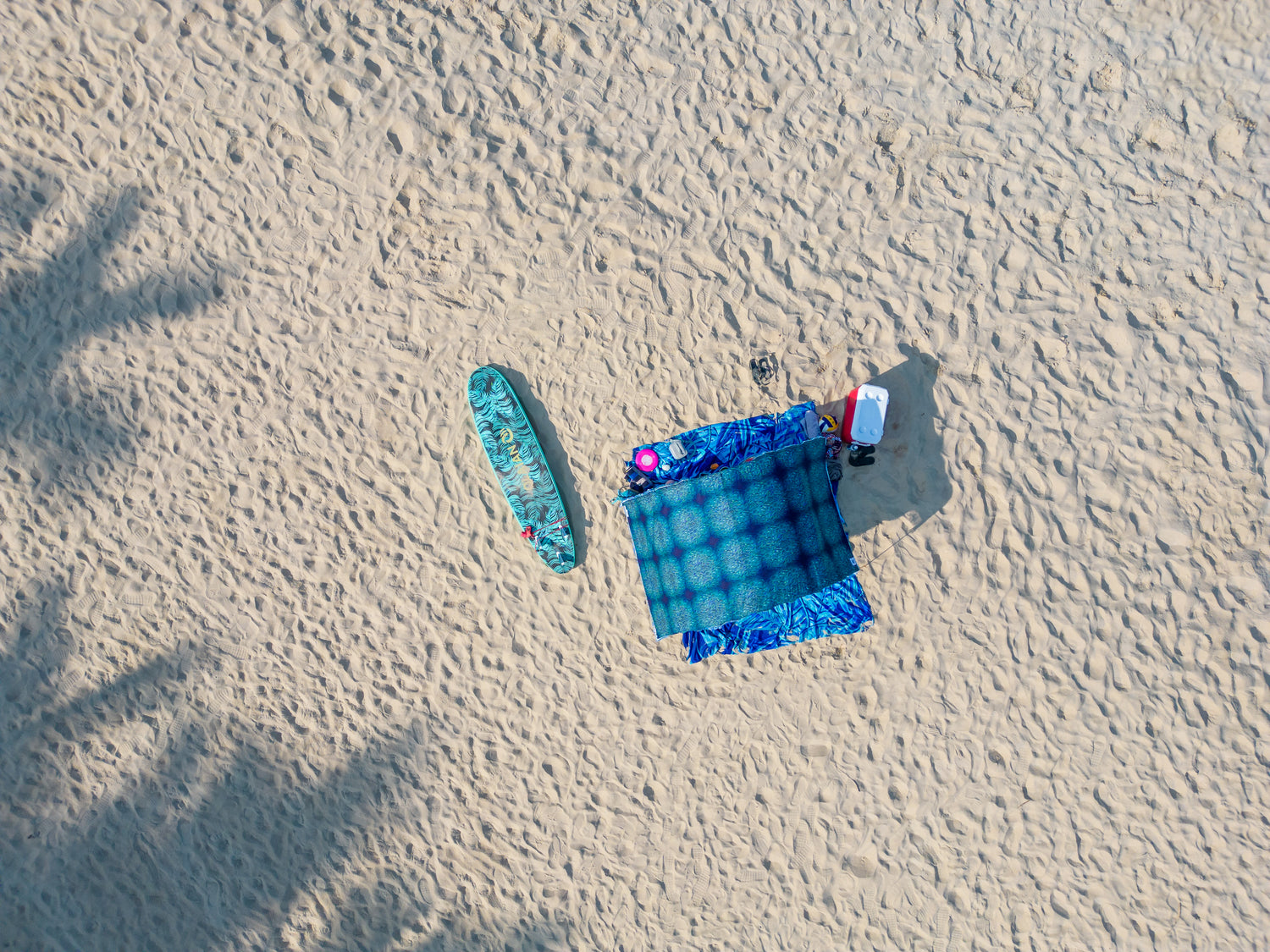 drone view from above of Suniela shade tent with a surfboard on a sandy beach